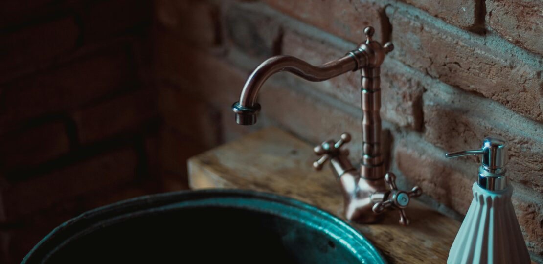 An ornate, dark wood antique bathroom vanity